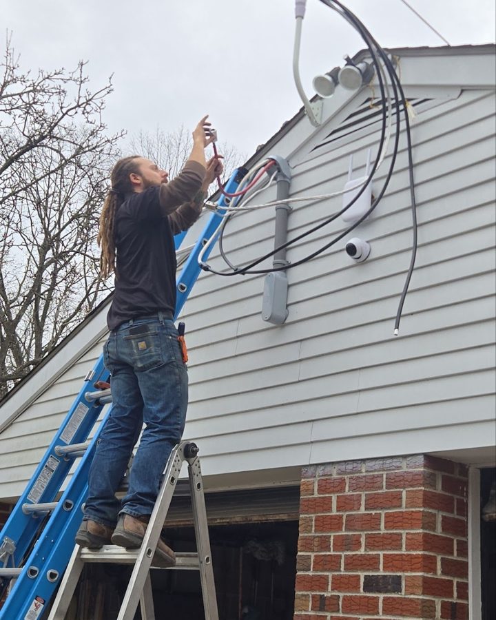 A 2 Live Wires electrician installing exterior service cables on a Lehigh Valley home